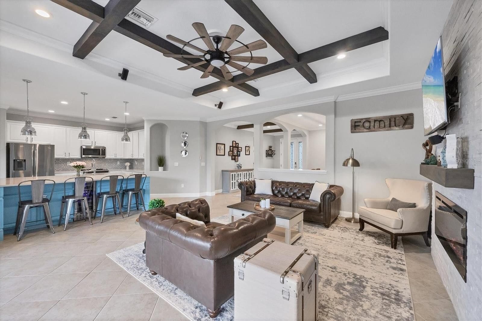 Living area with high ceiling and fireplace, open to the kitchen
