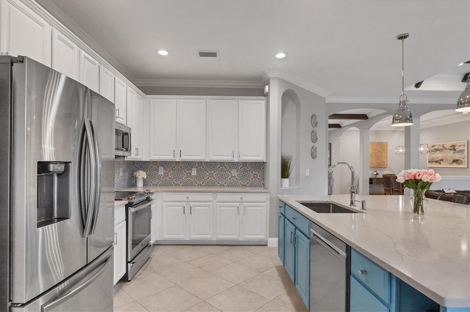 Kitchen with island, white cabinets and a blue accent wall