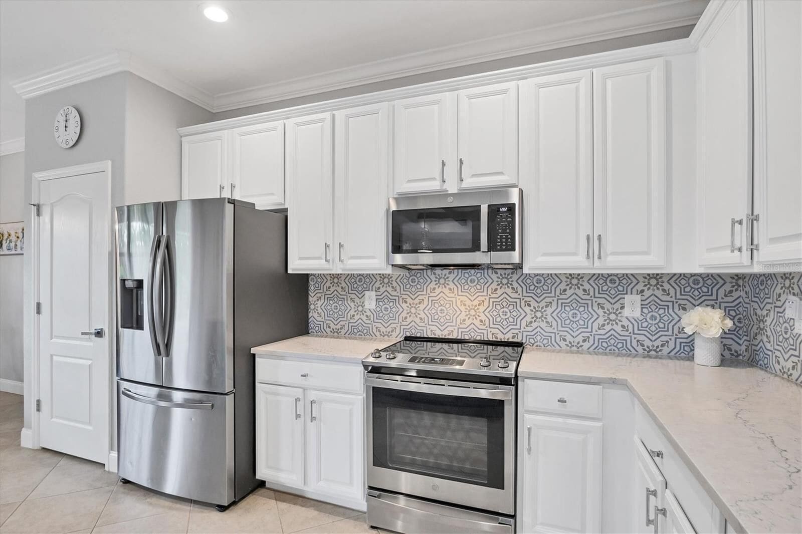 Kitchen with patterned backsplash and stainless appliances