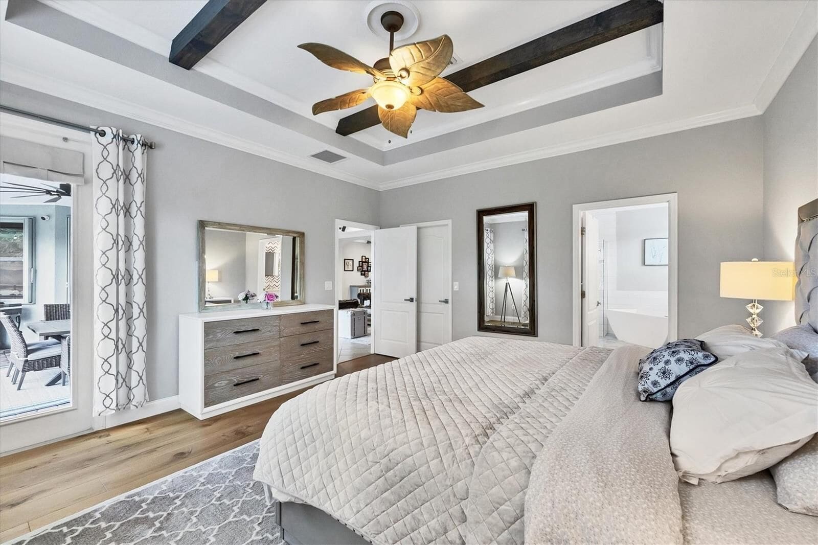 Bedroom with ceiling fan, dresser and mirror