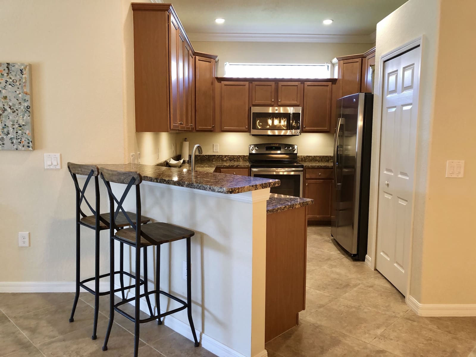 Kitchen with granite island, double oven and bar seating for two