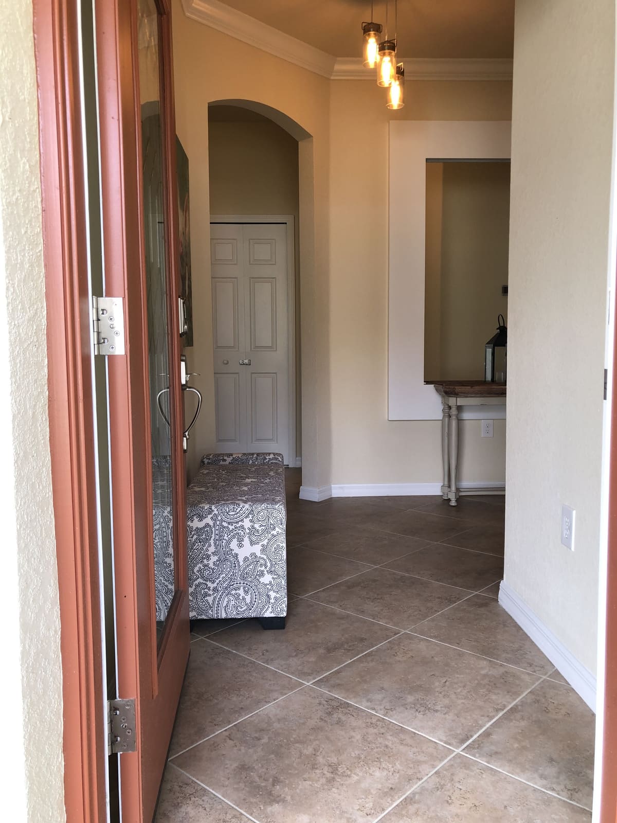 Hallway with a bench, looking through to the kitchen