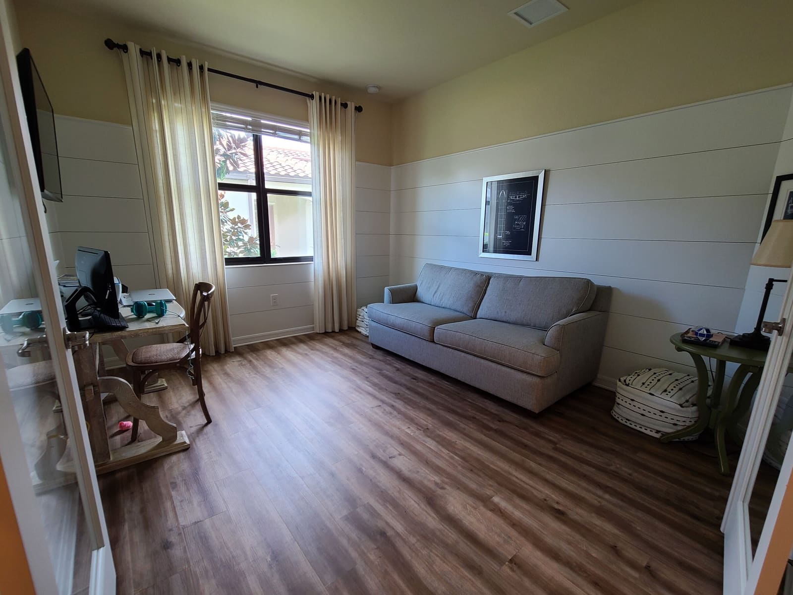 Den with a sofa and a desk